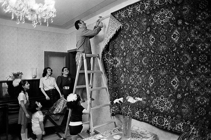 Глава семьи под восторженными взглядами своих родных прибивает к стене роскошный ковёр. СССР. 1970-е