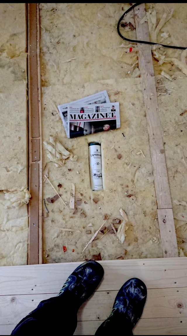 Плотник прячет газету и бутылку виски в полу, чтобы кто-нибудь нашел их спустя десятилетия