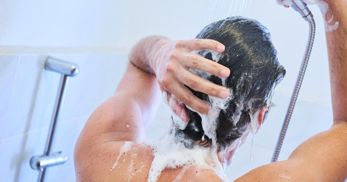 Мытье головы мылом мужчина. Мужик моет волосы. Сильный напор душа