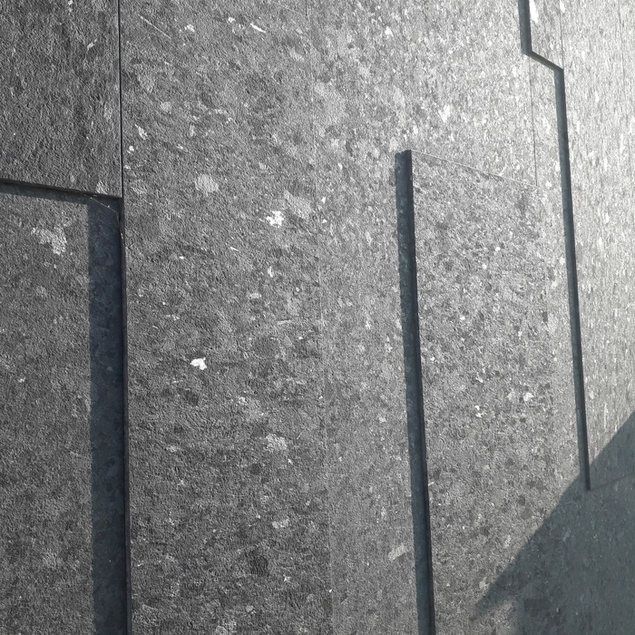 чёрная шершавая облицовка с зонами отблеска по ступеням спайности. Не видно следов механической обработки (царапин, штрихов), просто идеальная шершавая плоскость. Новострой, но технология для меня загадка, как Египетские пирамиды.