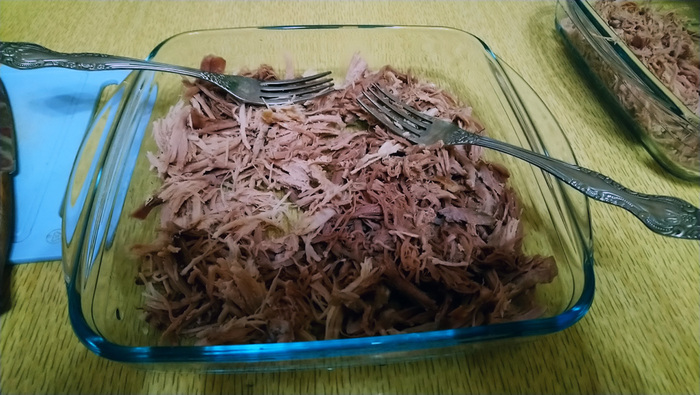 "Рвём" свинину вилками, все шкурки и жирок я убираю, оставляю только мясо, добавляем натёртый чеснок.