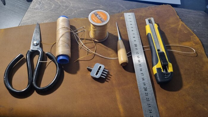 Ножницы (у меня специальные по коже), нить вощеная (я использую круглую для внешних швов и плоскую для внутренних), пробойник (у меня в виде насадки на пресс, но можно просто ударный), шило, металлическая линейка, канцелярский нож. А да, еще нужен клей.