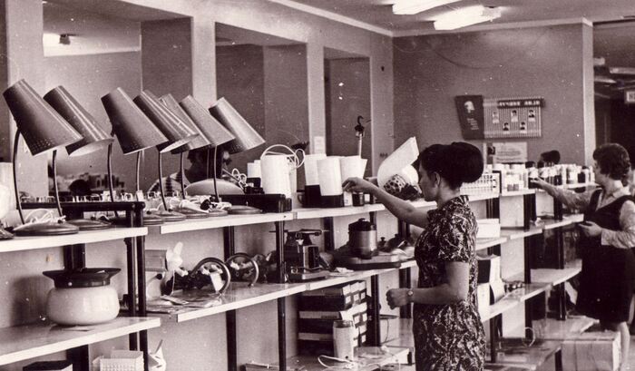 Расставляют товары по полкам. Наверное магазин "Энергия", или "Хозтовары", вернее второе, судя по второму ряду.