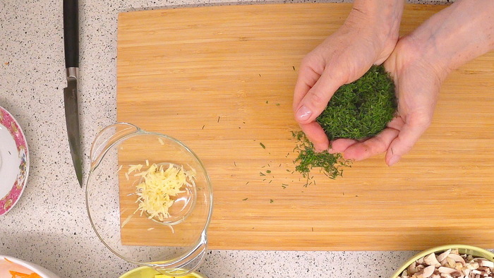 3 зубчика чеснока натираем на мелкой тёрке. Пучок зелени мелко нарезаем. Складываем их вместе.