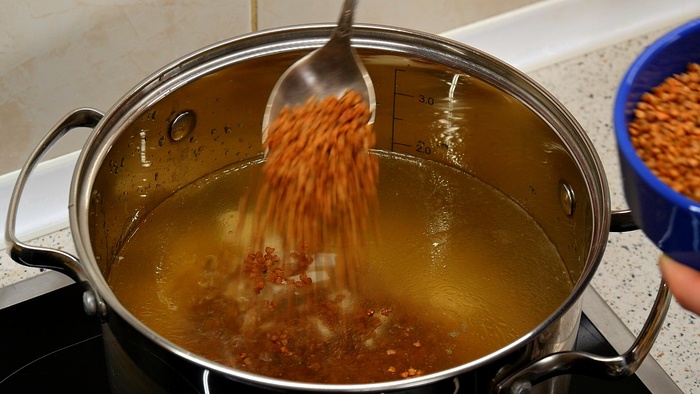 В холодный бульон отправляем нарезанную картошку, нарезанный сырок и 100 грамм гречки. Или 5-6 столовых ложек.