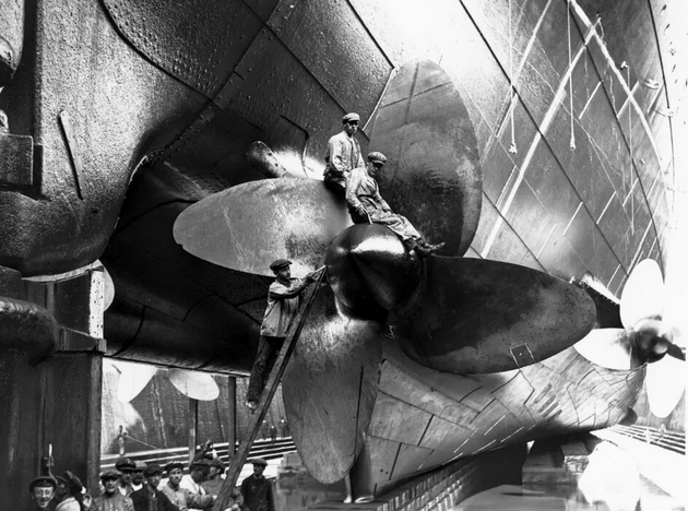 Люди работают над винтами торгового судна «Мавритания» во время его переоборудования в сухом доке Шербура, Франция, май 1924 года.