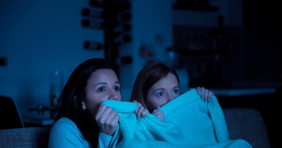компания друзей смотрит фильм ужасов в темноте и пугается