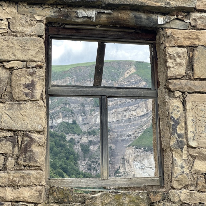 Фото окна со стороны улицы. Гора внутри дома.