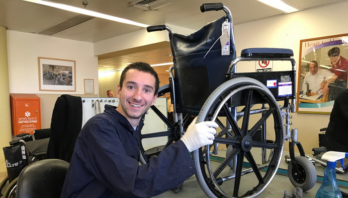 Волонтер по имени Йона ремонтирует инвалидную коляску в Яд Сара. Фото Эбигейл Кляйн Лейхман