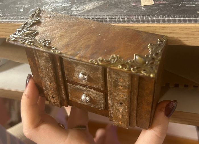 У нас есть маленький комод из переплетного картона и фурнитуры для шкатулок. Комод полый, сзади от него крепится аккумулятор для огоньков внутри башни