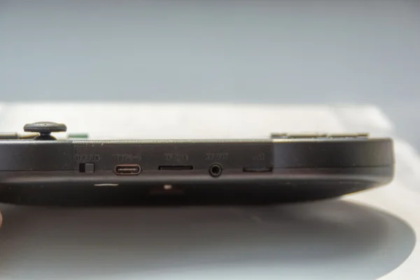 Снизу по порядку расположен: переключатель включения устройства, разъем для зарядки, слот для карты памяти micro sd, видео выход и колёсико регулировки громкости. 