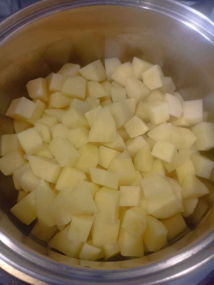 Пока всё это жарилось - режем кубиками заранее очищенный картофель, кладём в кастрюлю.