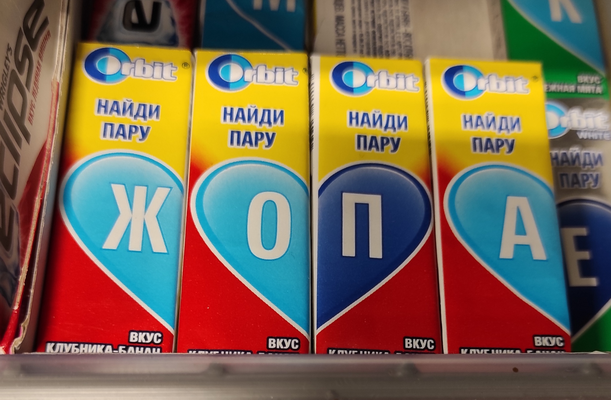 круглая жвачка в коробочке. самая дешевая жевательная резинка. жвачка на белом фоне. жвачка орбит с буквой м. жевательная резинка.